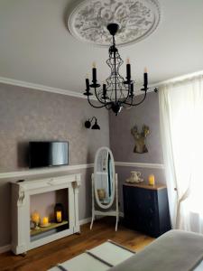 a living room with a fireplace and a chandelier at La Belle Epoque in Kerlaz