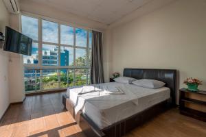 a bedroom with a bed and a large window at Hotel Orbita Ureki in Ureki