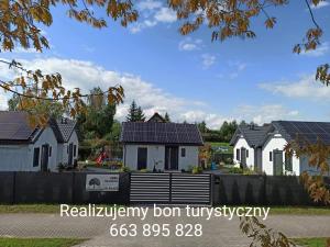 a row of white houses with roofs at Domki pod Katalpami in Mikołajki
