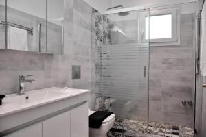 a bathroom with a shower and a toilet and a sink at Althea Village House in Akhladherí +40 photos