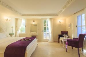 a bedroom with a large bed and a table and chairs at Lukka Exclusive Hotel – Adult Only +12 in Kaş