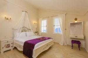 a bedroom with a white bed with a canopy at Lukka Exclusive Hotel – Adult Only +12 in Kaş