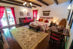 - une chambre avec un lit, une table et un canapé dans l'établissement Pousada Villa D'Amore, à Monte Verde