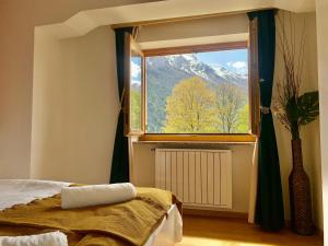 una camera da letto con finestra affacciata su una montagna di Casa di Franz a Vigo di Fassa