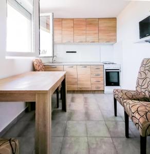 a kitchen with a wooden table and chairs in it at Apartments Siesta in Tivat