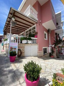 a pink house with potted plants in front of it at Villa Antonis in Parga