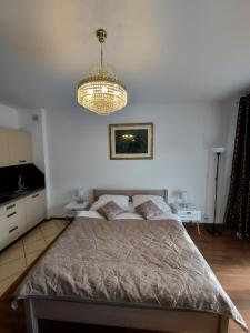 1 dormitorio con cama y lámpara de araña en Regina Maris, en Świnoujście