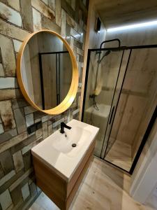 a bathroom with a sink and a mirror at Apartament Jurata Deluxe in Jurata