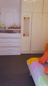 una cocina con armarios blancos y una cama en una habitación en Iva new room with private bathroom en Zadar