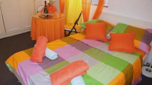Una cama colorida con almohadas coloridas. en Iva new room with private bathroom en Zadar