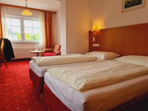 A bed or beds in a room at Hotel Wirt im Feld
