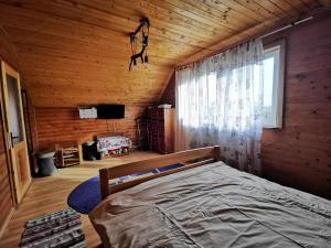 a bedroom with a bed in a wooden room at Jugul Țăranului Agropensiune Polovragi, Gorj in Polovragi