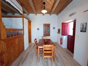a dining room with a wooden table and chairs at Anemos Guest House Karpathos in Olympos
