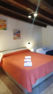 サバウディアにあるColle La Guardiaのベッドルーム1室(オレンジ色のベッド1台、タオル付)