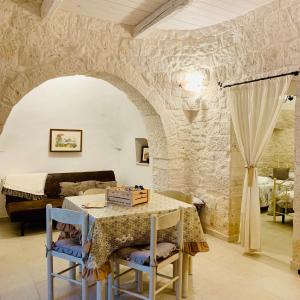 uma sala de jantar com uma mesa e um sofá em Trulli Pietra Viva em Alberobello