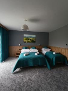 a bedroom with two beds with green comforters at Wynajem u Patryka in Poronin