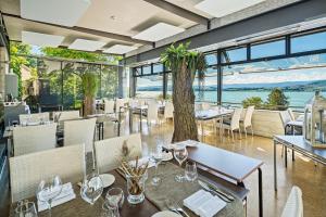 un ristorante con tavoli e sedie e vista sull'oceano di Hotel Murtenhof & Krone a Murten