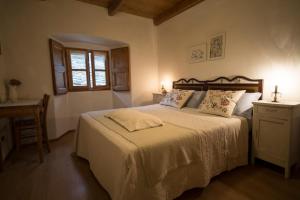 a bedroom with a bed and a table and a window at bb chiavenna centro storico in Chiavenna