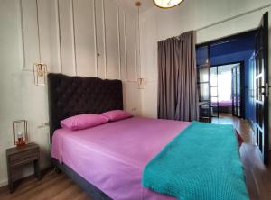 テッサロニキにあるLuxury Apartments Aristotelousのベッドルーム1室(ピンクとグリーンのシーツを使用した大型ベッド1台付)