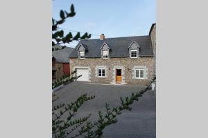 uma grande casa de tijolos com uma entrada em Le Petit Concise à 20mn du Mont Saint Michel em Saint-James