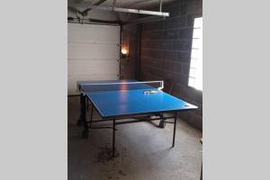 a ping pong table in a room with a brick wall at Le Petit Concise à 20mn du Mont Saint Michel in Saint-James