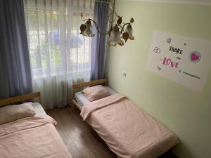 two twin beds in a room with a window at Hostel4u in Gdańsk