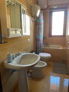 łazienka z umywalką i toaletą w obiekcie Caravaggio Apartment w mieście Porto Cesareo