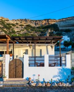 a white house with a wooden pergola at Tsampika's Beachfront House in Stegna in Archangelos