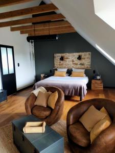 een slaapkamer met 2 stoelen en een bed in een kamer bij La Belle Epoque in Kerlaz