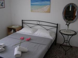 1 dormitorio con 1 cama con toallas y espejo en AGERI STUDIOS en Skala Kallirakhis