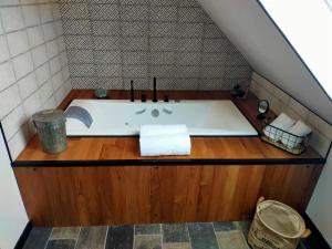 a bath tub in a bathroom with a wooden floor at La Belle Epoque in Kerlaz