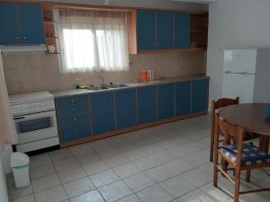 a kitchen with blue cabinets and a table and a sink at Konstantina's House II in Koroni