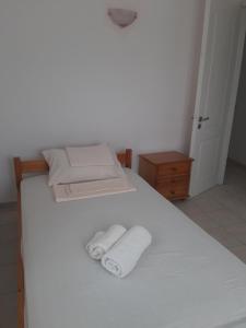 a white bed with two folded towels on it at Konstantina's House II in Koroni