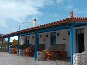 a blue and white building with chairs and tables at Filio rooms in Kythira