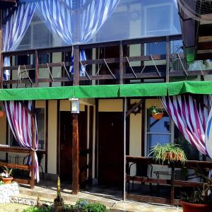 a building with a balcony with tables and chairs at U Palycha Guest House in Sukhum