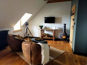 a living room with a couch and a television at La Belle Epoque in Kerlaz