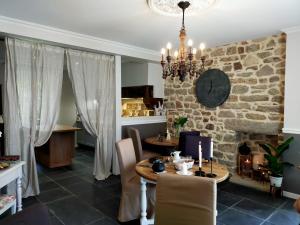 a dining room with a table and a stone wall at La Belle Epoque in Kerlaz