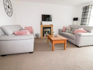 a living room with two couches and a coffee table at 13 Manorcombe Bungalows in Callington