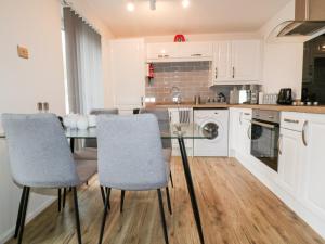 a kitchen with a glass table and chairs at 13 Manorcombe Bungalows in Callington