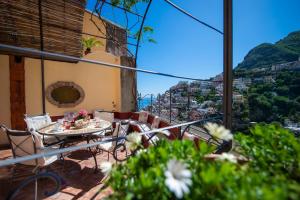 balkon ze stołem i krzesłami oraz widokiem na miasto w obiekcie Casa Giulia - sophisticated apartment with view w mieście Positano