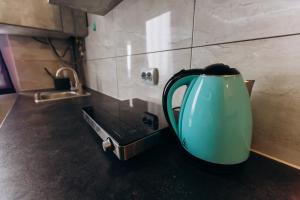 a green tea kettle sitting on a counter in a kitchen at — Premium apartment — in Ivano-Frankivsʼk
