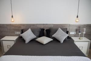 een groot bed met kussens en 2 nachtkastjes bij Spacious 200 sq.m. penthouse with sea view terraces in Torremolinos