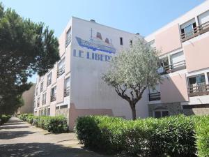 ein Gebäude mit einem Schild an der Seite in der Unterkunft LE LIBERTE - Studio cabine à 2 pas de la plage et du port in Saint-Cyprien