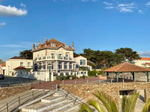 ein großes weißes Gebäude mit einer Treppe davor in der Unterkunft Hôtel de charme & SPA Le Grand Large in La Bernerie-en-Retz