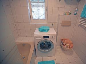 a bathroom with a washing machine and a tub at Ferienwohnung Maria in Ebbs
