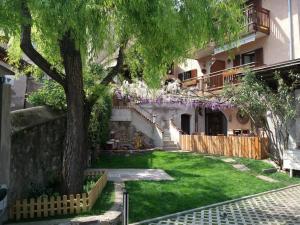 un cortile con un albero e un edificio di Haus Möltner - Apartment 1927 a Caldaro Altre 4 foto
