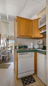 a kitchen with wooden cabinets and a white dishwasher at Sea Crest in Amagansett