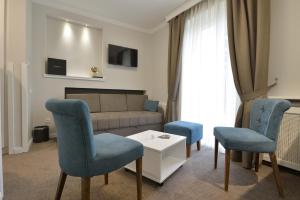 a living room with blue chairs and a couch at Vila Savka in Vrnjačka Banja