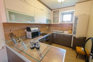 a large kitchen with a glass counter top in a room at Божурите in Gabrovo