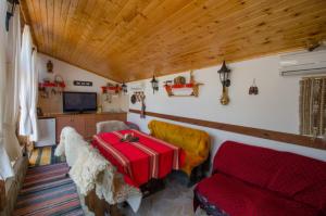 a living room with a couch and a red suitcase at Божурите in Gabrovo